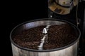 Fresh coffee beans and roasted spinning cover professional machine close up photo and black background