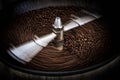 Fresh coffee beans and roasted spinning cover professional machine close up photo and black background long exposure shot and