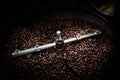 Fresh coffee beans and roasted spinning cover professional machine close up photo blur and dark background long exposure shot