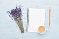 Fresh coffee, clean notebook and lavender flower on blue background from above. Woman working desk. Cozy breakfast. Flat lay. Royalty Free Stock Photo