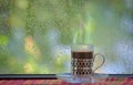 Fresh coffee cup at rainy window