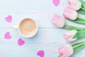 Fresh coffee and pink tulip flowers on pastel background top view. Beautiful spring breakfast on Mothers or Womans day. Flat lay. Royalty Free Stock Photo