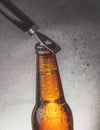 Fresh cold beer ale bottle with drops and stopper open with bottle opener Royalty Free Stock Photo