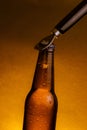 Fresh cold beer ale bottle with drops and stopper open with bottle opener Royalty Free Stock Photo