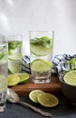 Fresh cold cocktail Mojito with lime and mint in three glasses with water drops on a wooden stand with a towel and a spoon. Royalty Free Stock Photo