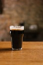 fresh cold dark beer with foam in glass on wooden table Royalty Free Stock Photo