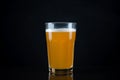 Fresh and cold glass craft beer with white foam on top on black background with space for text. Foamy wheat or lager beer on dark Royalty Free Stock Photo