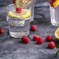 Fresh cold ice water drink with lemon, raspberry fruits and mint leaf in glass on stone concrete background Royalty Free Stock Photo