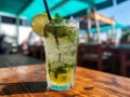 Fresh Mohito cocktail on the wooden table served in beach bar on summer day. Generative AI