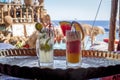 Fresh Cold Orange and Raspberry Cocktails and mojito on Table on Beach with Sunny Sea. Fruit Mocktails in Beach Restaurant. Iced Royalty Free Stock Photo
