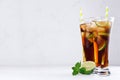 Fresh cold summer drink of cola, ice, lime, leaf mint on soft light white background, copy space. Royalty Free Stock Photo