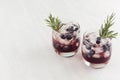 Fresh cold summer fruit cocktails with ice cubes, blueberry, rosemary on white wood board, top view. Royalty Free Stock Photo