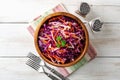 Fresh coleslaw salad with red and white cabbage and carrots in bowl on white wooden background Royalty Free Stock Photo