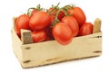 Fresh and colorful italian roma tomatoes on the vine in a wooden crate