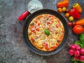 Fresh, colorful pizza with vegetables and a cutter