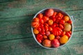 Fresh colorful ripe Fall heirloom tomatoes in basket over wooden background, top view, horizontal composition Royalty Free Stock Photo