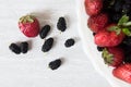 Colorful strawberries and mulberries in white bowl Royalty Free Stock Photo