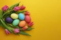 Fresh colorful tulip flowers and easter eggs on yellow background. Top view with copy space. Happy easter greeting card