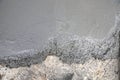 Fresh concrete mixture spreads over an old rough ground surface during active construction work Royalty Free Stock Photo