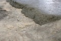 Fresh concrete mixture spreads over the rough ground surface during active construction work Royalty Free Stock Photo