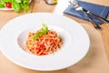Fresh, cooked Italian spaghetti, pasta with marinara or tomato sauce decorated with basil on the white plate served on the wooden Royalty Free Stock Photo
