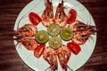 Fresh cooked shrimps with limes, tomatos on white plate. Red prawns. Healthy delicious seafood dinner lunch. Diet concept. Sea Royalty Free Stock Photo