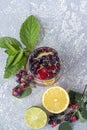 Fresh cool detox drink with berries and lemon. Glass of lemonade or infuse water, tea with leaves mint. Proper nutrition and Royalty Free Stock Photo