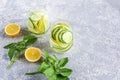 Fresh cool detox water drink with cucumber and lemon. Two glass of Lemonade with basil and mint leaves. Concept of proper Royalty Free Stock Photo