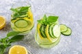 Fresh cool detox water drink with cucumber and lemon. Two glass of Lemonade with basil and mint leaves. Concept of proper Royalty Free Stock Photo