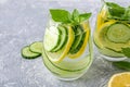 Fresh cool detox water drink with cucumber and lemon. Two glass of Lemonade with basil and mint leaves. Concept of proper Royalty Free Stock Photo