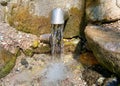 A fresh and cool spring flows from the ground. Cool and delicious spring water. Natural underground water source