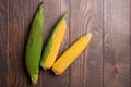 Fresh corn cobs on flat wooden background Royalty Free Stock Photo