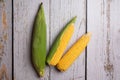 Fresh corn cobs on flat wooden background Royalty Free Stock Photo