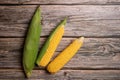 Fresh corn cobs on flat wooden background Royalty Free Stock Photo