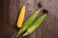 Fresh corn cobs on flat wooden background Royalty Free Stock Photo