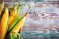 Fresh corn on cobs on wooden table, closeup. Background with copy space. Selective focus. Top view. Royalty Free Stock Photo