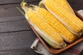 Fresh corn on cobs on wooden table, closeup, top view. Dark background with copy space Royalty Free Stock Photo