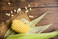 Fresh corn on sack and sweet corn seed on rustic wooden table background