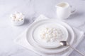 Fresh cottage cheese grain in a white bowl and marshmallows. Curd in granules with cream. Copy space Royalty Free Stock Photo