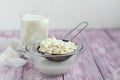 Fresh cottage cheese in a transparent bowl with raisins. In the background is a glass of kefir. Fermented foods. Good bacteria for