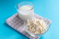 Fresh cottage cheese in a transparent bowl with a spoon with a glass of kefir on a blue background. Fermented foods. Good bacteria