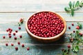 Fresh cowberry lingonberry, partridgeberry, foxberry in wooden bowl on rustic vintage table.