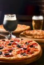 Fresh craft beer and pizza with vegetables and meat. Party concept, different kinds of pizza with delicious craft beer Royalty Free Stock Photo