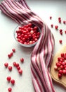 Fresh cranberries in a glass Cup and scattered on the kitchen table, Burgundy napkin, gray background, vertical frame Royalty Free Stock Photo