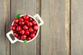 Fresh cranberry in white ceramic bowl on wooden background Royalty Free Stock Photo