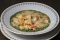 Fresh creamy salmon fish soup with potatoes, carrots, broccoli, peppers and onions in a ceramic plate on a wooden table, closeup. Royalty Free Stock Photo