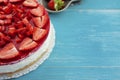 Fresh creamy strawberry cake on wooden background