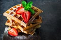 Fresh crisp Belgian waffles with ripe strawberries, mint and honey for breakfast on a wooden board Royalty Free Stock Photo
