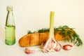 Fresh crispy baguette with garlic oil and herbs. A delicious still life of baguette, young garlic, fresh dill and a glass bottle