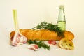 Fresh crispy baguette with garlic oil and herbs. A delicious still life of baguette, young garlic, fresh dill and a glass